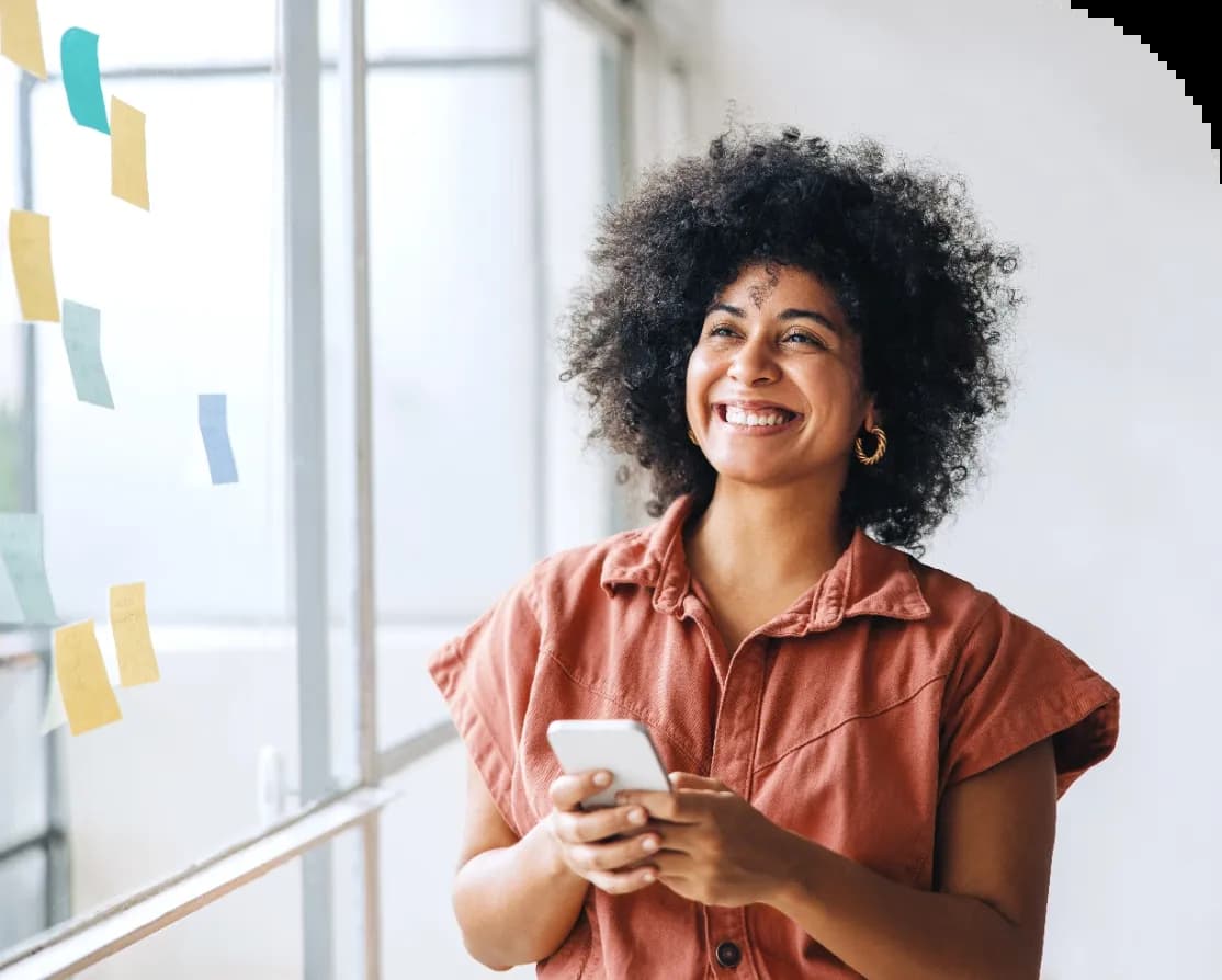 Mulher sorrindo com um smartphone na mão